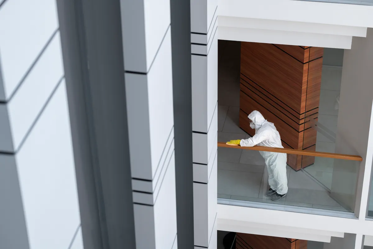 Operario con traje de protección limpiando una superficie con detalle