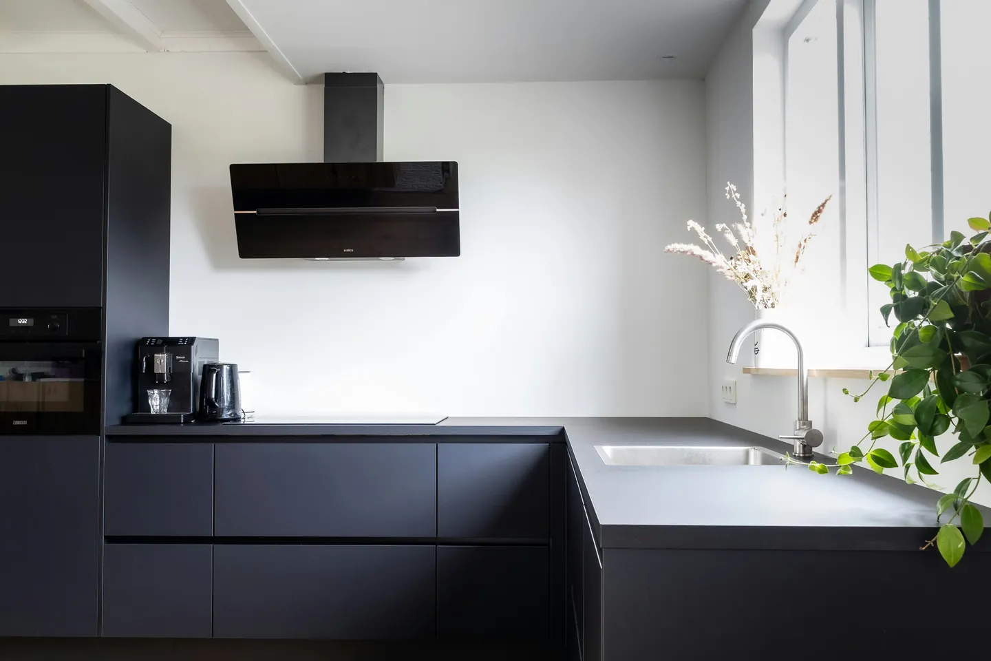 Cocina moderna en negro mate con isla y luz natural